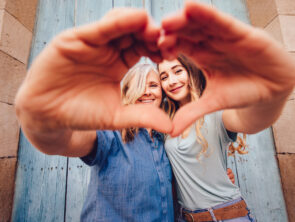 Two women doing a heart with hands